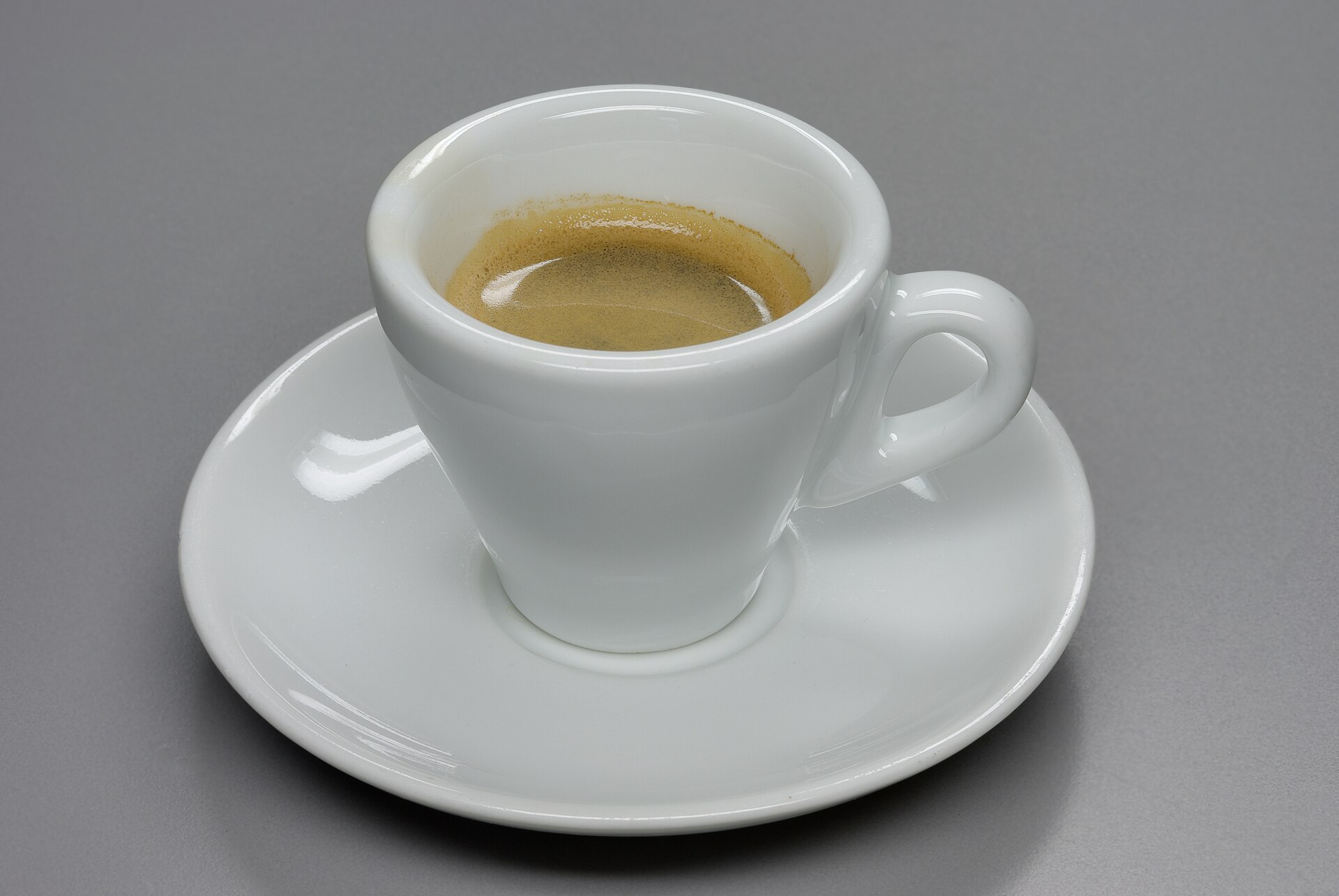 A small demitasse of espresso on a saucer